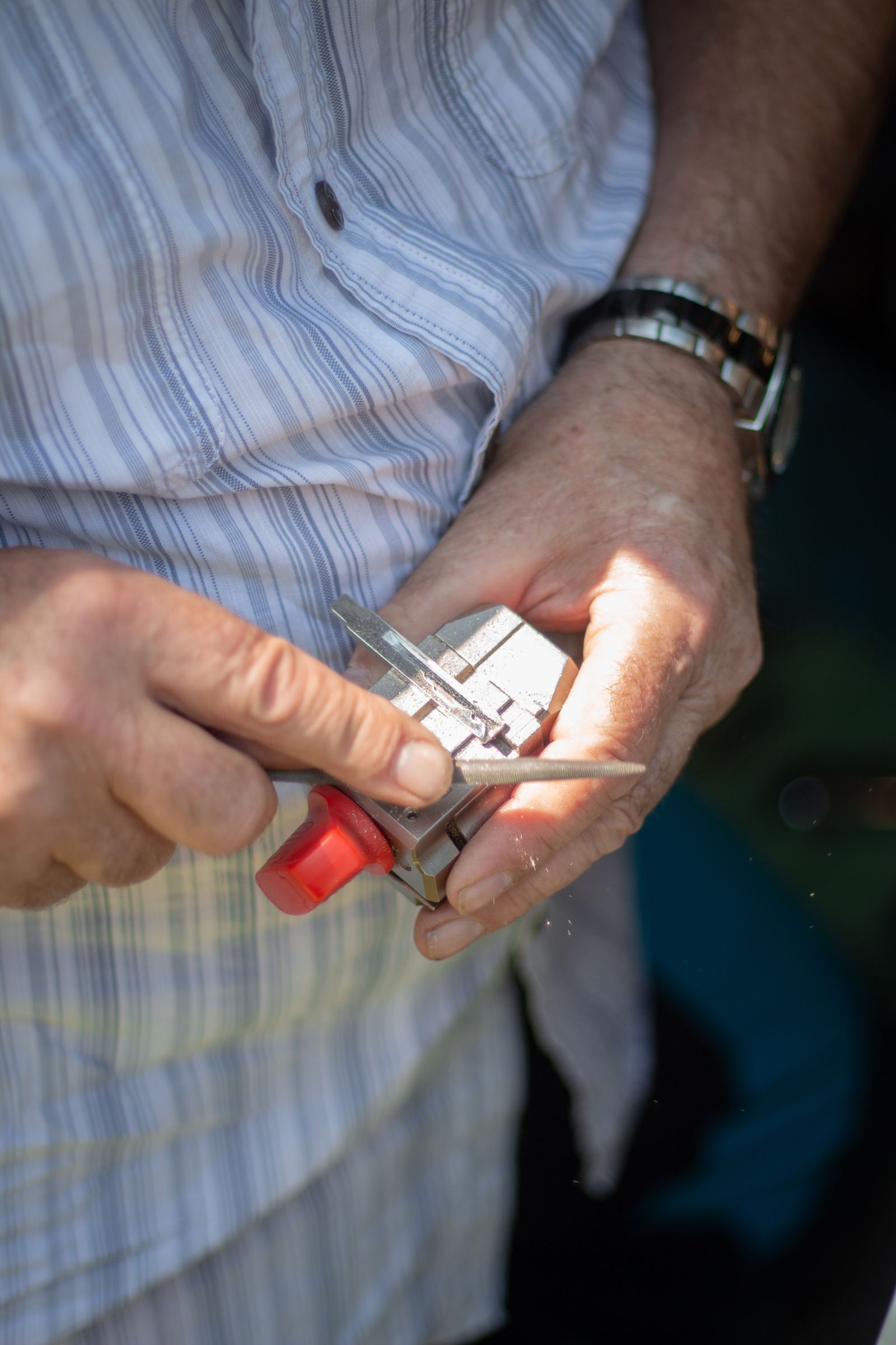 A locksmith repairing a worn door lock and realigning the strike