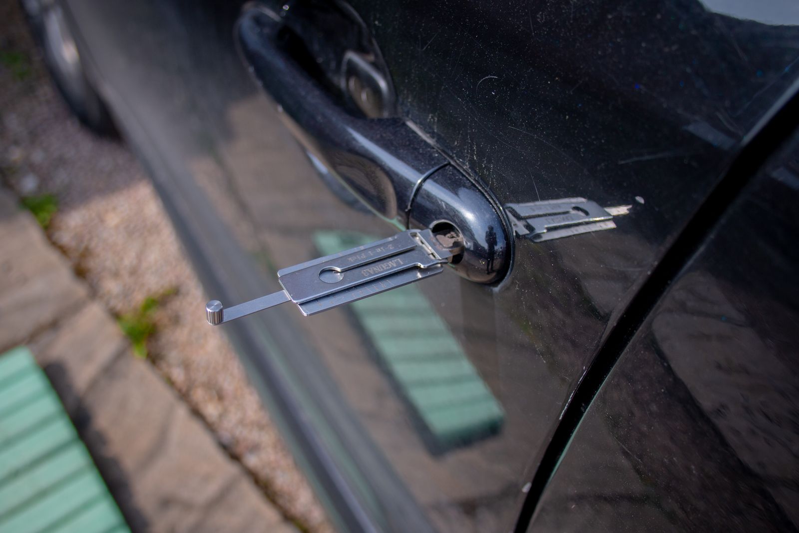 A locksmith unlocking a car door without damage during a vehicle lockout