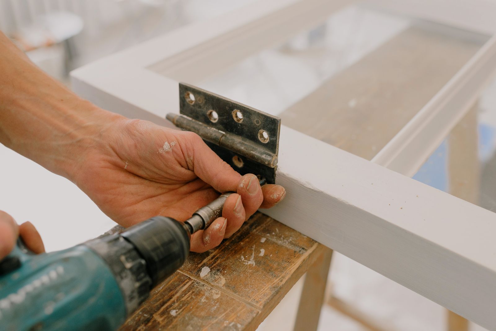 A locksmith servicing the lock on a commercial storefront door